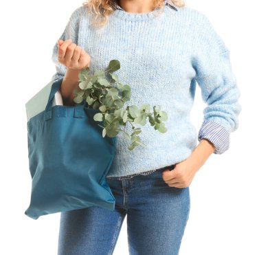 Beyaz arka plan üzerinde eko çanta içinde kitap ve okaliptüs ile Kadın, closeup