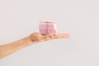 Hafif arkaplanda sabun çubukları olan bir kadın el