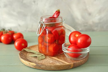 Ahşap masada konserve domates ve biber ile Kavanoz
