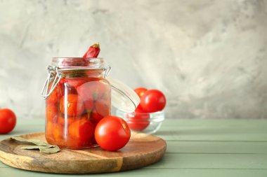 Ahşap masada konserve domates ve biber ile Kavanoz