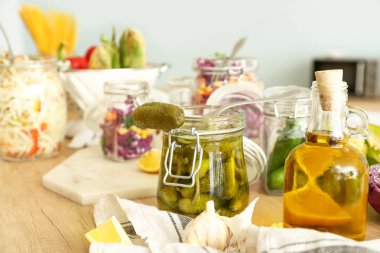 Mutfakta ahşap masada konserve salatalık ile Kavanoz