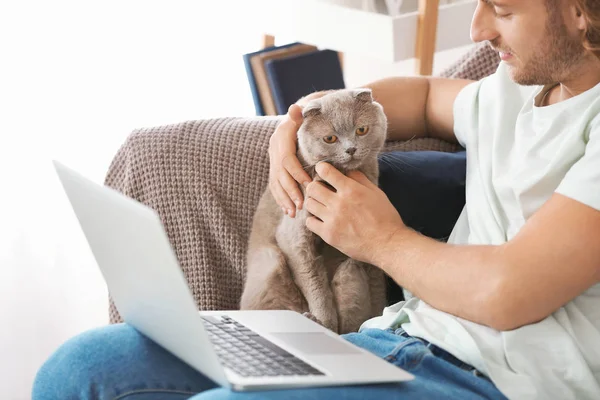 Hombre con portátil y lindo gato divertido en casa —  Fotos de Stock
