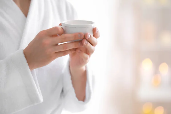 Young man in bathrobe drinking coffee at home, closeup — Stock Photo, Image
