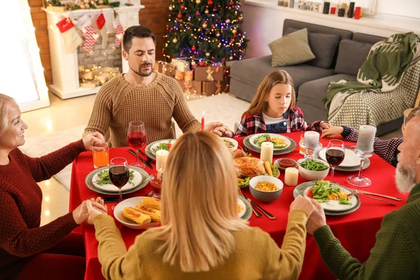 Família rezando antes de ter jantar de Natal em casa — Fotografia de Stock