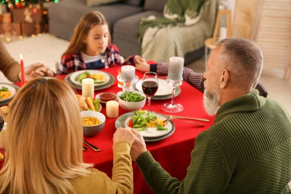 Family praying before having Christmas dinner at home — Stock Photo, Image