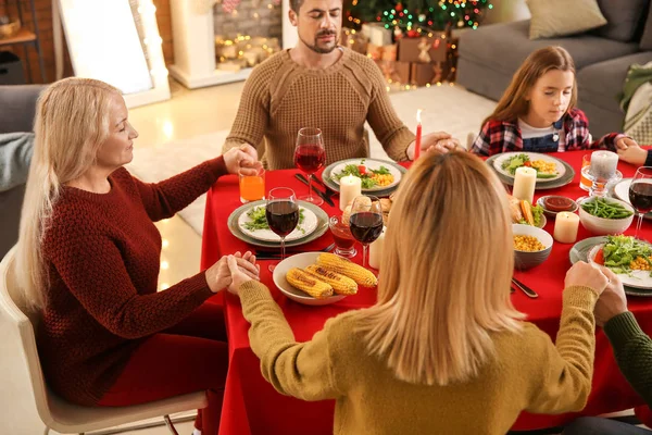 Família rezando antes de ter jantar de Natal em casa — Fotografia de Stock