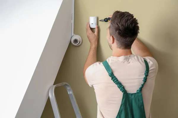 Electrician installing alarm system indoors — Stock Photo, Image