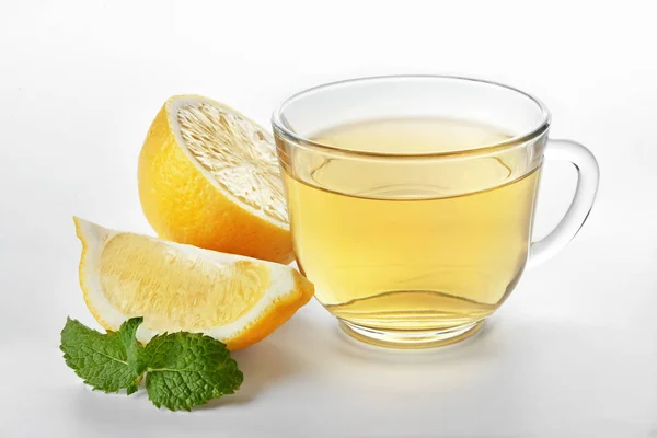 Glass cup of tasty tea with mint and lemon on white background — Stock Photo, Image