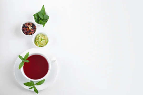 Cup of hot tea with lime and mint on white background — Stock Photo, Image