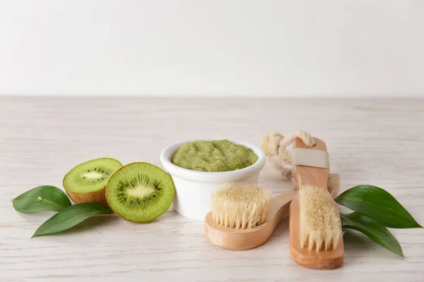 Esfregue com kiwi e escovas na mesa de madeira branca — Fotografia de Stock