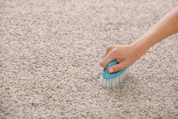 Kvinna rengöring fluffiga mattan hemma — Stockfoto