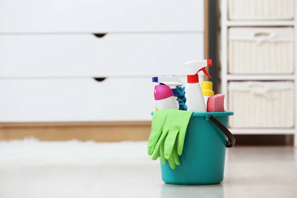 Balde com suprimentos de limpeza no chão no quarto — Fotografia de Stock