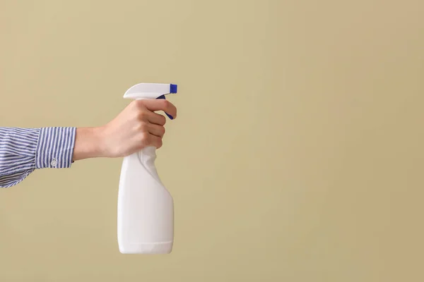 Mano femenina con botella de limpiador sobre fondo de color — Foto de Stock