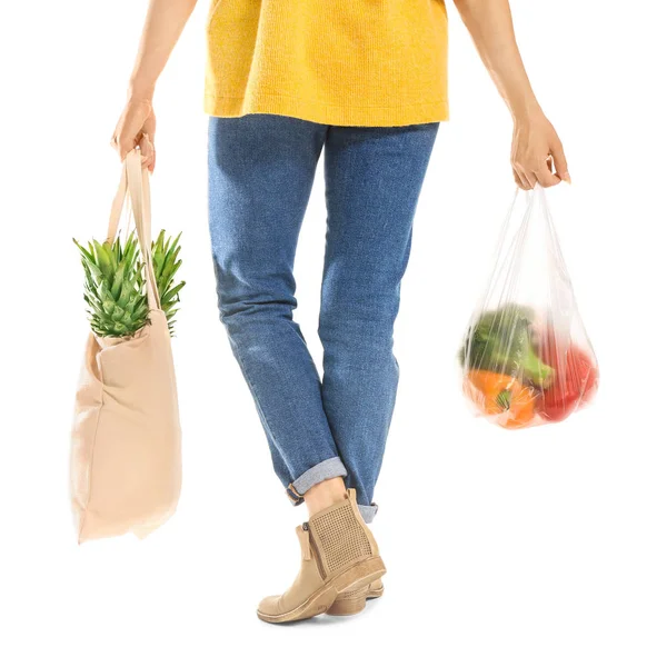 Woman with fresh products in different bags on white background, back view. Ecology concept — Stock Photo, Image