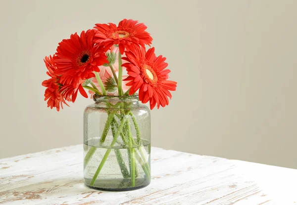 Vaas met mooie gerbera bloemen op tafel — Stockfoto