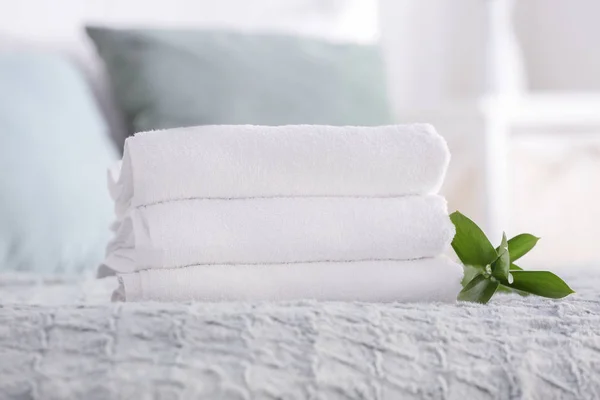 Stack of clean towels on bed — Stock Photo, Image