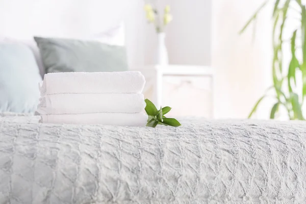 Stack of clean towels on bed — Stock Photo, Image