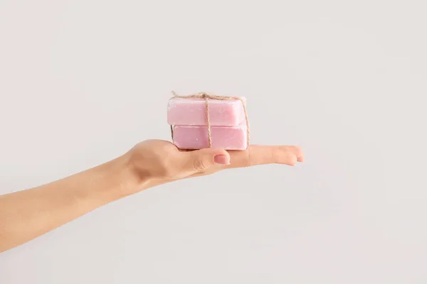 Female hand with soap bars on light background — Stock Photo, Image