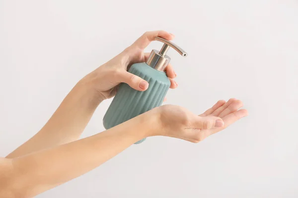 Female hands with soap in bottle on light background — Stock Photo, Image