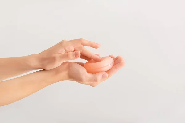 Vrouwelijke handen met zeep bar op lichte achtergrond — Stockfoto