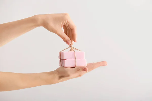 Manos femeninas con barras de jabón sobre fondo claro — Foto de Stock