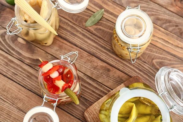 Jars with canned vegetables on wooden table — Stock Photo, Image