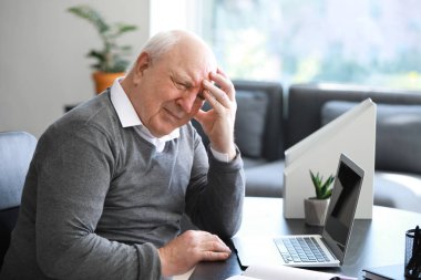 Ofiste baş ağrısı çeken kıdemli adam