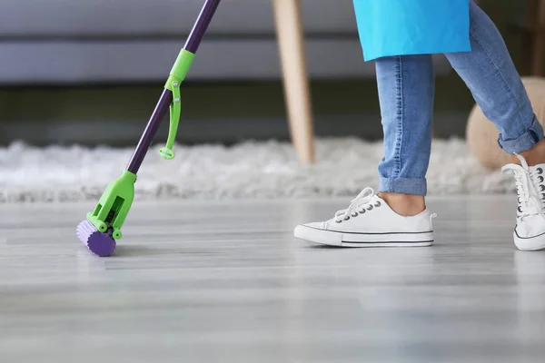 Donna che pulisce pavimento in camera — Foto Stock