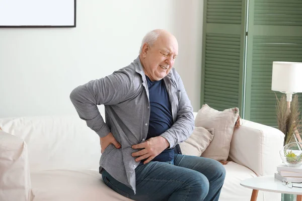 Hombre mayor que sufre de dolor de espalda en casa — Foto de Stock