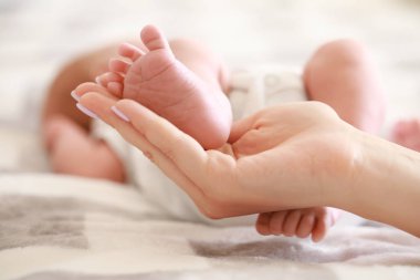 Küçük bebek bacaklı anne eli, yakın çekim