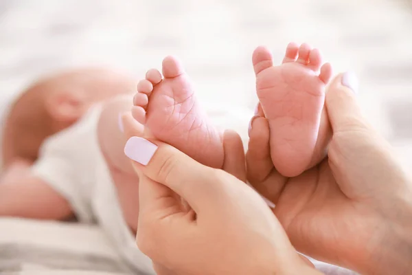 Las manos de la madre con pequeñas piernas de bebé, primer plano —  Fotos de Stock