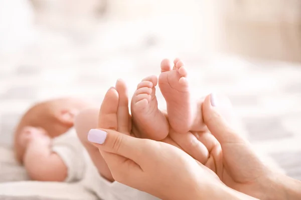 Las manos de la madre con pequeñas piernas de bebé, primer plano —  Fotos de Stock