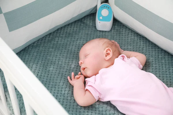 Cute little baby with radio nanny sleeping in crib — Stock Photo, Image