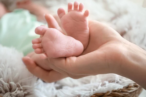 Mano de madre con pequeñas piernas de bebé, primer plano —  Fotos de Stock