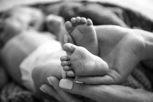 Mãos de mãe com pernas de bebê minúsculas, close-up — Fotografia de Stock