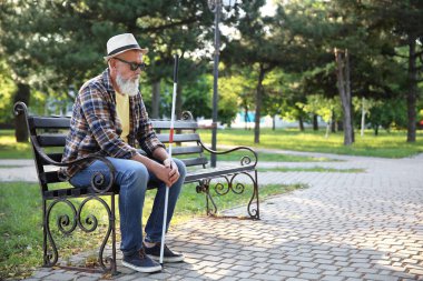 Kör olgun adam parkta bankta oturan