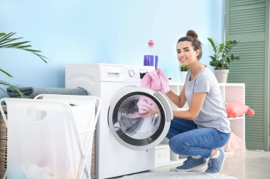 Güzel genç bayan evde çamaşır yıkıyor.