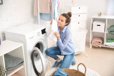 Güzel genç bayan evde çamaşır yıkıyor.