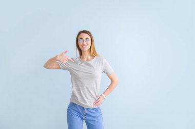 Kadın renkli arka plan karşı onu t-shirt işaret