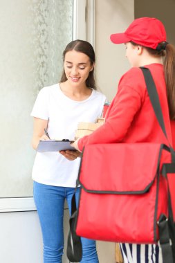 Yemek dağıtım şirketinden sipariş aldığını onaylayan belgeleri imzalayan kadın.