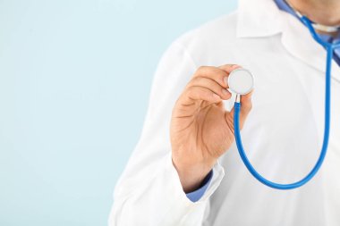 Açık renk arka plan üzerinde stetoskop ile erkek doktor, closeup