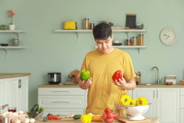 Yakışıklı Asyalı adam mutfakta yemek