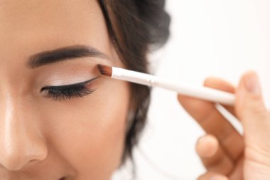 Profesyonel makyaj sanatçısı evde genç Asyalı gelin ile çalışan, closeup