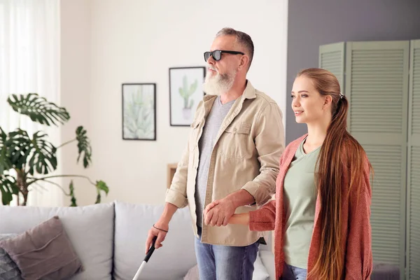 Vrouw helpt blinde volwassen man thuis — Stockfoto