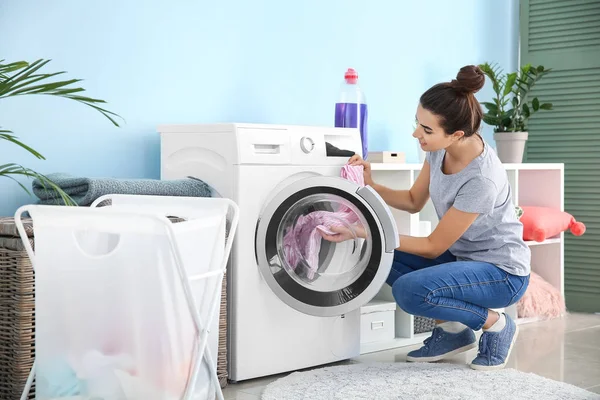 Vacker ung kvinna gör tvätt hemma — Stockfoto