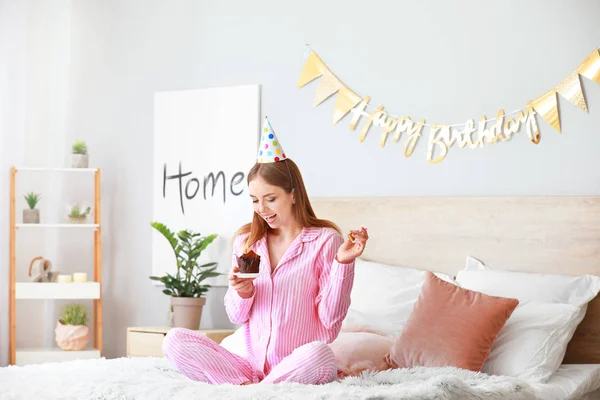 Mujer feliz con pastel de cumpleaños en el dormitorio en casa —  Fotos de Stock