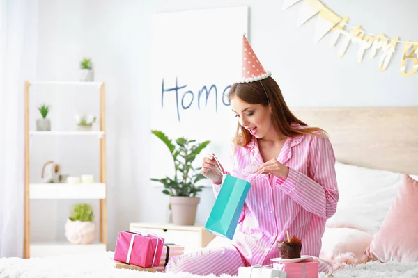 Boldog nő ajándékokat neki születésnap hálószoba otthon — Stock Fotó