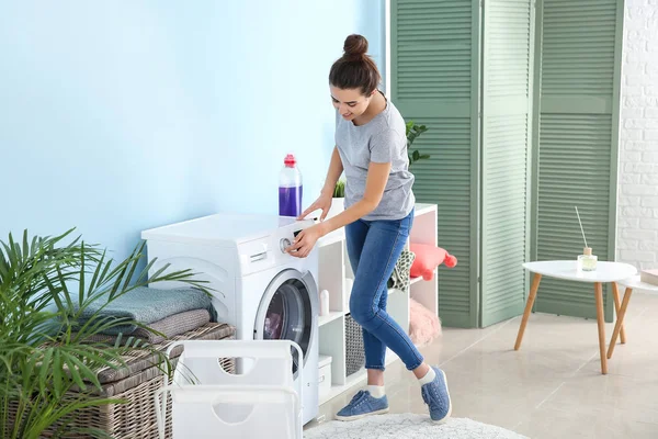 Vacker ung kvinna gör tvätt hemma — Stockfoto
