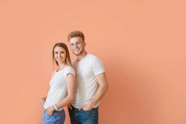 Couple in stylish t-shirts on color background