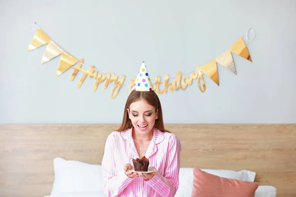 Mujer feliz con pastel de cumpleaños en el dormitorio en casa —  Fotos de Stock